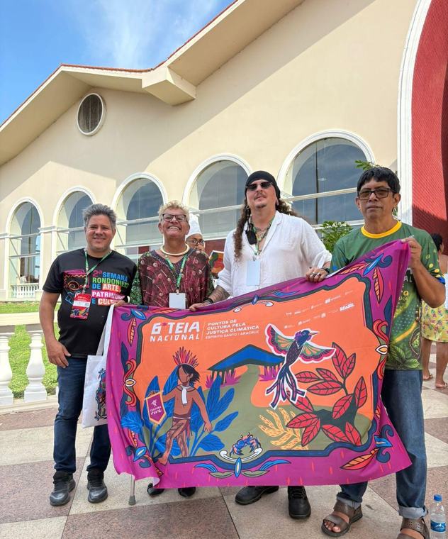 Integrantes do coletivo seguram a bandeira da 6ª Teia Nacional dos Pontos de Cultura, em Aracruz (ES).