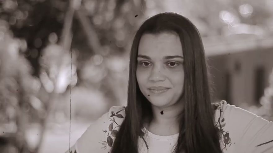 Cena em preto e branco do curta Dona Lídia: retrato de uma mulher de cabelos longos ao ar livre.